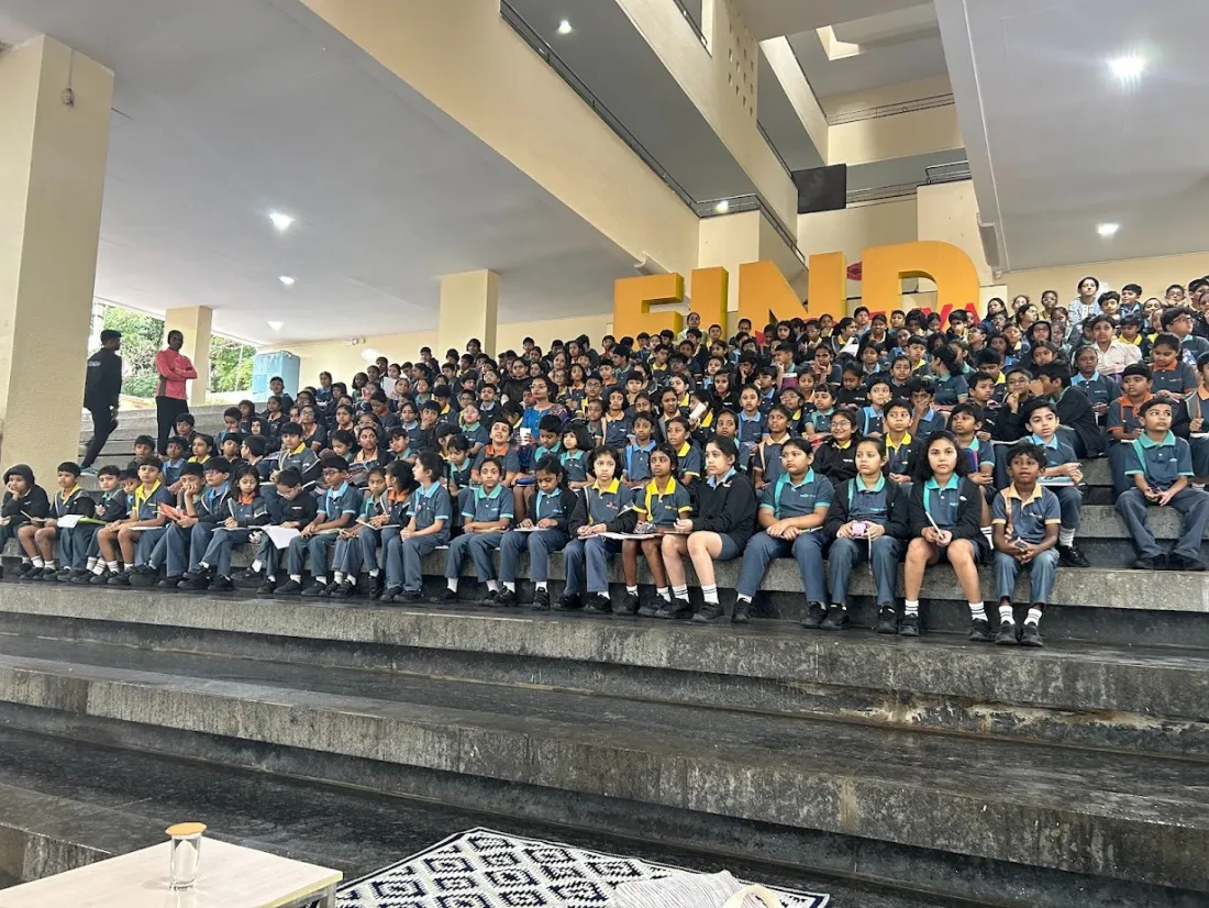 Students seated on tiered amphitheatre steps at an author talk