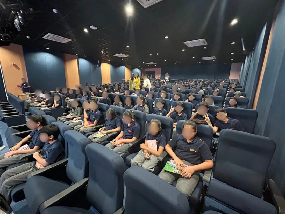 Students listening to an author talk in a school auditorium